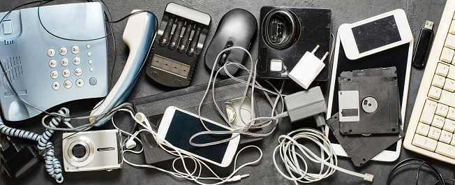 Old electronic devices on a dark background. The concept of recycling and disposal of electronic waste
