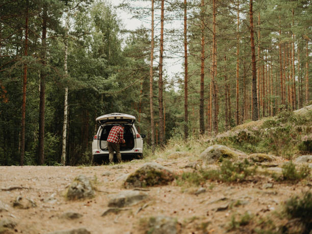 istock Man out in nature by a with car 1414148661