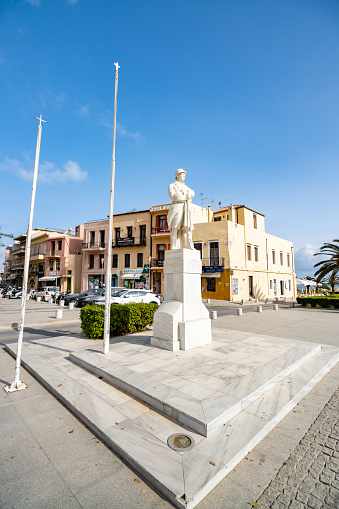 People and vehicles visible near The Statue of the Unknown Soldier on Agnostou Square at Rethymnon Town on Crete, Greece, was erected in 1930 and was designed by Eleftherios Venizelos to mark the anniversary of the Arcadian self-sacrifice and the centenary of Greek independence.