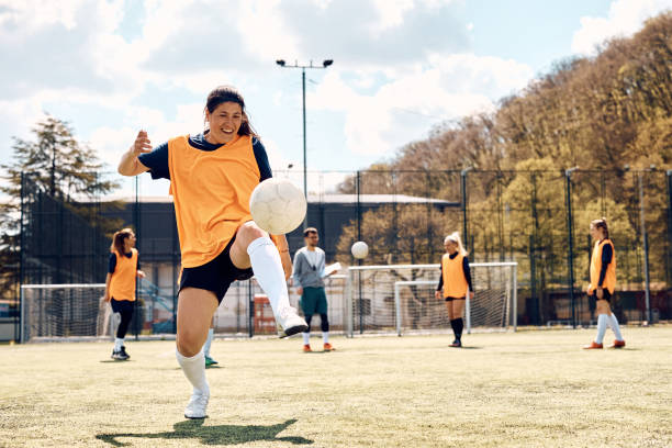 istock Happy female player practicing with ball during soccer training on playing field. 1414150108