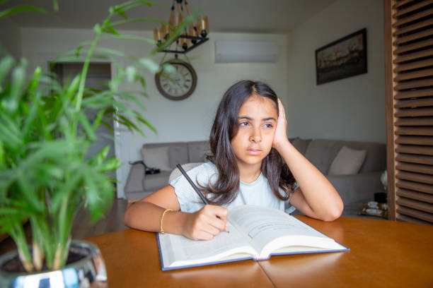 istock Little girl reading a book 1414150929