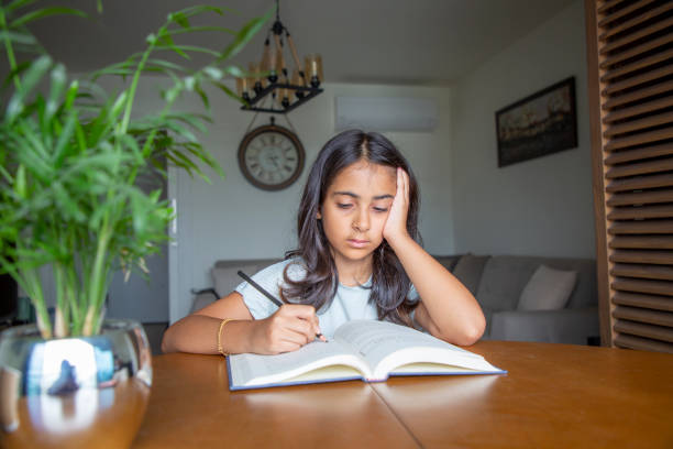 istock Little girl reading a book 1414150940