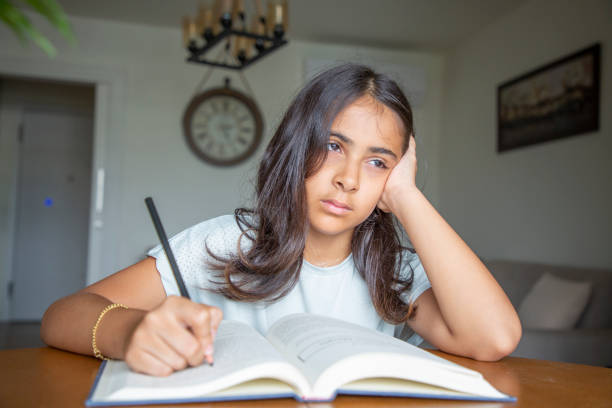 istock Little girl reading a book 1414151045