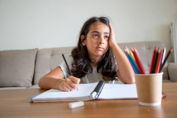 istock A small girl doing homework at a desk at home 1414151507