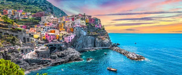 Beautiful landscape with colorful buildings on the hill along the coastline. Popular tourist destination. Manarola, one of the five villages of National Park Cinque Terre, La Spezia, Liguria, Italy, Europe. Wide image.