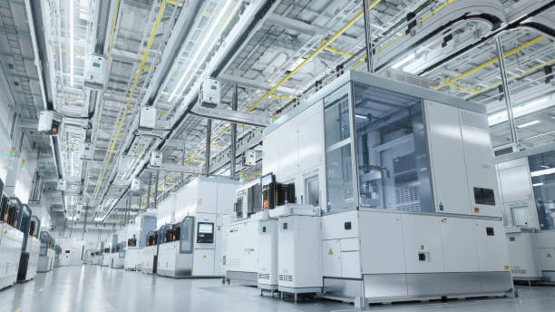 作業オーバーヘッドウェーハ転送システムを備えた明るい高度な半導体生産ファブクリーンルームの内部 - 工場 ストックフォトと画像