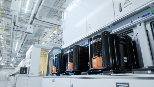 istock Row of Wafer FOUPs Inside Bright Advanced Semiconductor Production Fab Cleanroom with Working Overhead Wafer Transfer System 1414159188