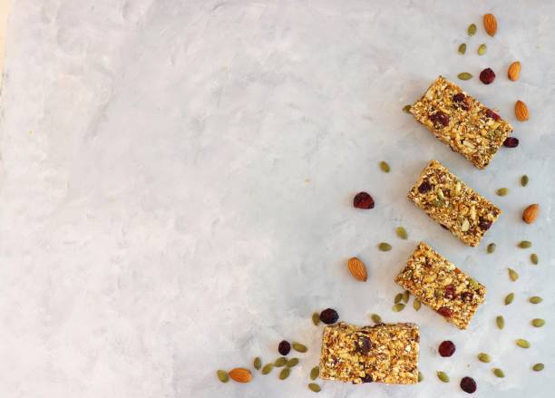 istock Super food breakfast Granola bars with Oats, Almonds, Cranberries, Pumpkin seeds, Flax seeds, Honey and Dates. flat lay on textured background with ingredients. with copy space. 1414159607