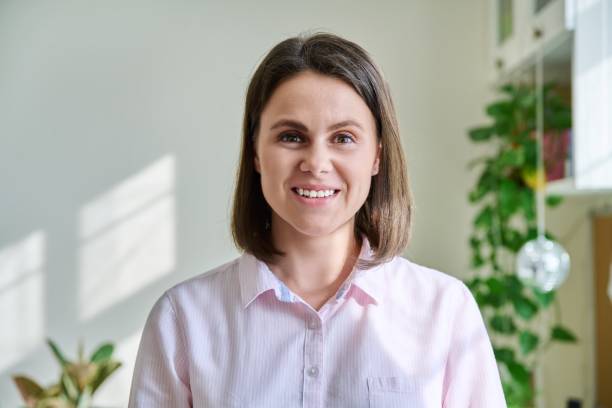 istock Headshot young smiling woman looking at camera in home interior 1414171109