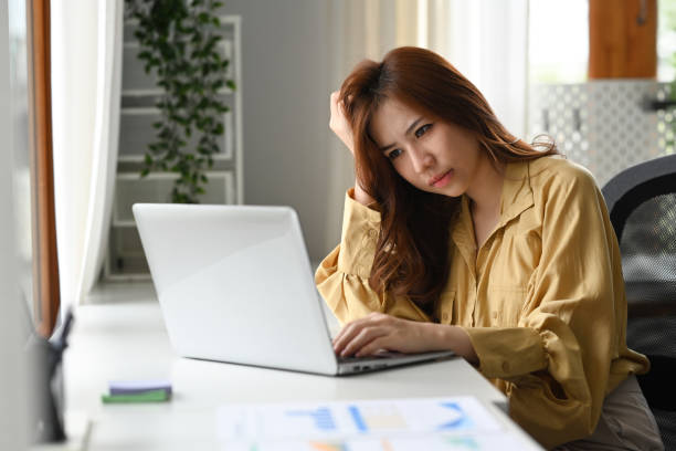 istock Upset female office worker holding her head on hands while sitting at her workplace. Emotional pressure, stress at work concept. 1414171151