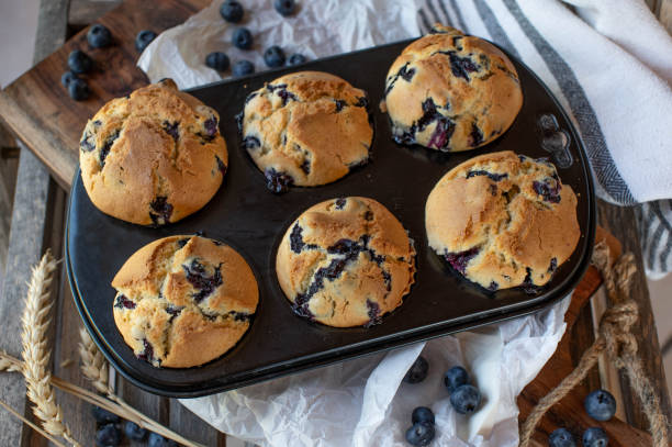 muffins de arándanos en una lata de muffins - muffin cake cupcake blueberry muffin fotografías e imágenes de stock