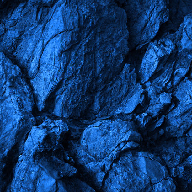istock Rock texture. Navy blue color. Toned rough mountain surface with cracks. Close-up. Stone granite background for design. 1414173713