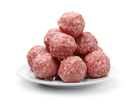 Heap of fresh raw meatballs on plate isolated on white