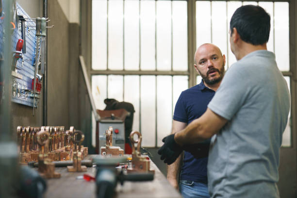 istock Blue collar worker and designer working on a metal part 1414180396