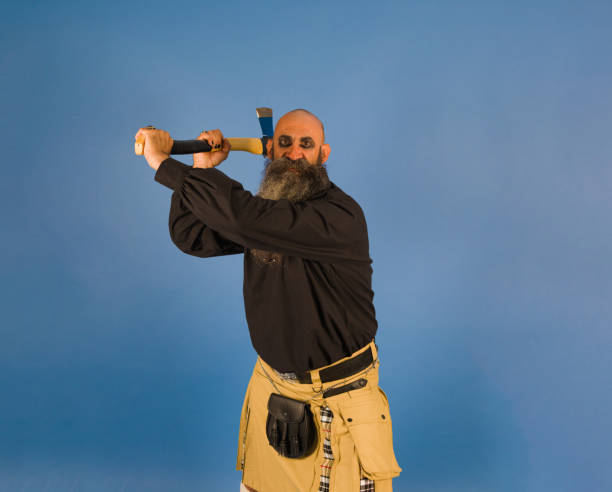 istock bald head long bearded man holding up an axe with attack intension and expression of anger | halloween | drama | horror | storytelling 1414180706
