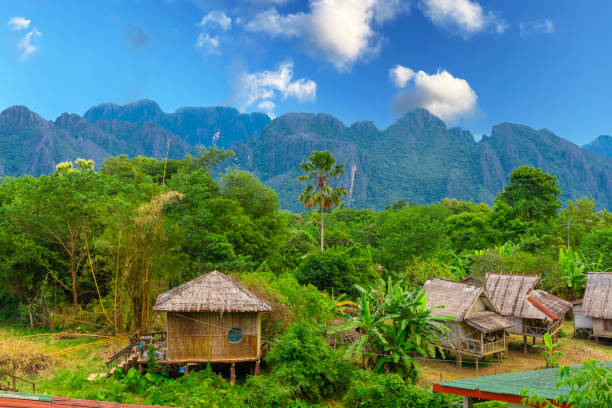 vang vieng laos una bellissima città sul fiume con enormi montagne in aumento e fiume che scorre lento. - vang vieng foto e immagini stock