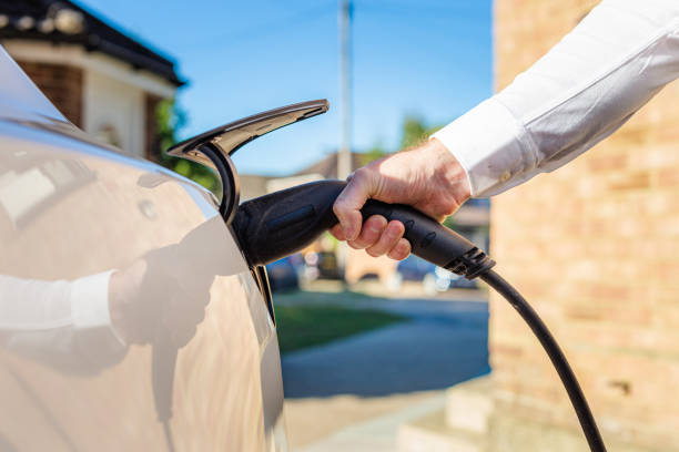 istock Man charging electric car at home 1414184257