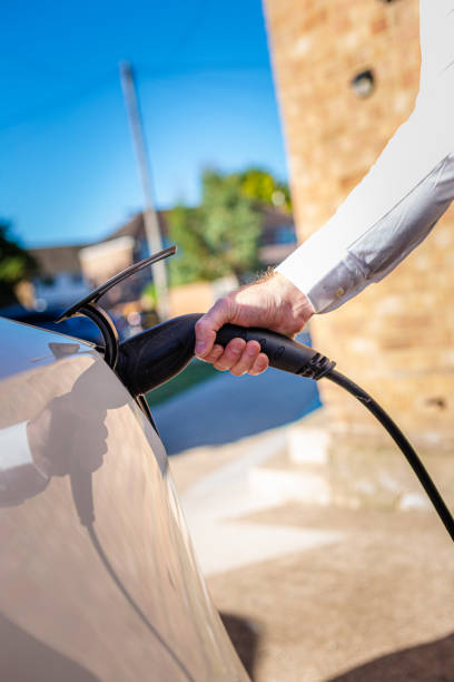 istock Man charging electric car at home 1414184263