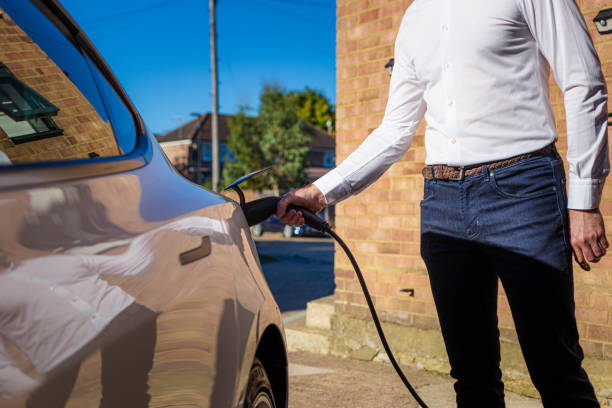 istock Man charging electric car at home 1414184298
