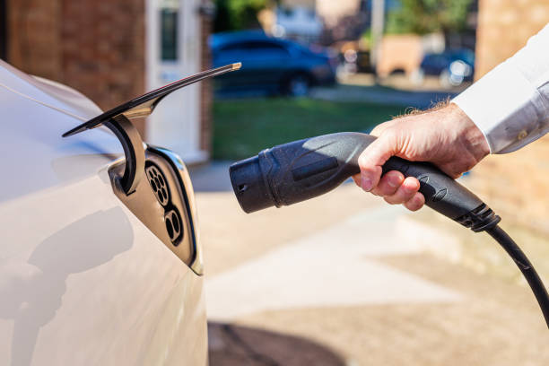 istock Man charging electric car at home 1414184300