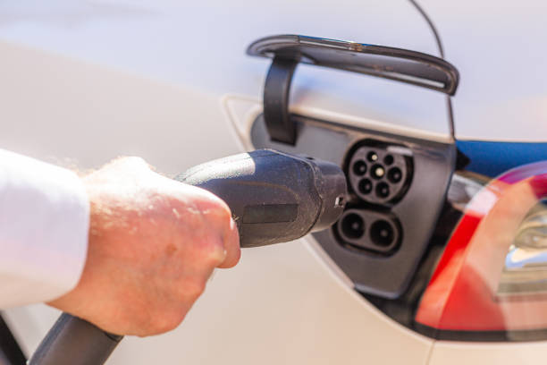 istock Man charging electric car at home 1414184302