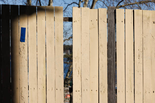 Close-up on an old wooden fence with a missing panel.