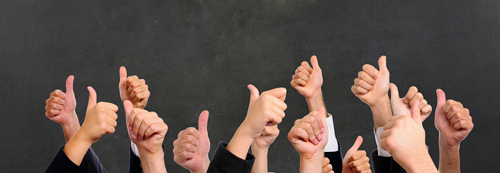 Business Persons Showing Thumbs Up against a black background.