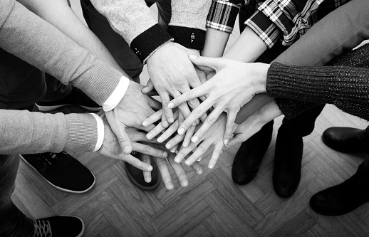Business persons stacking hands. Unity or cooperation concept.