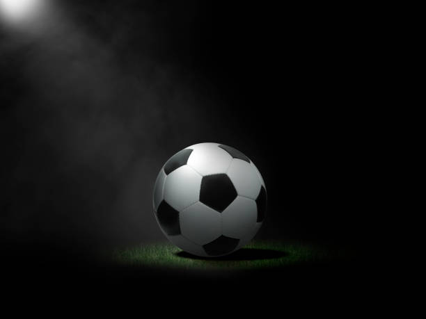 istock Soccer ball on lawn with black background 1414186989