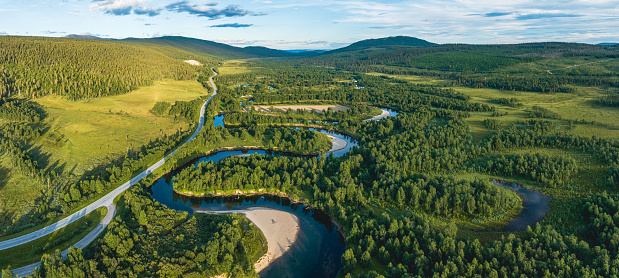 The river of Ljusnan runs like a snake through deep green forest and meadows. Along the many curves of the river there are sand beaches. Seen from above in the village of Bruksvallarna, Harjedalen, Sweden.