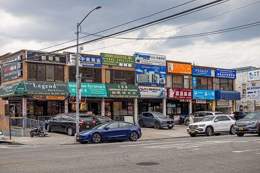 Flushing downtown, Queens, New York, NY, USA - July 2 2022: Row of American Chinese shops and small industries along College Point Boulevard