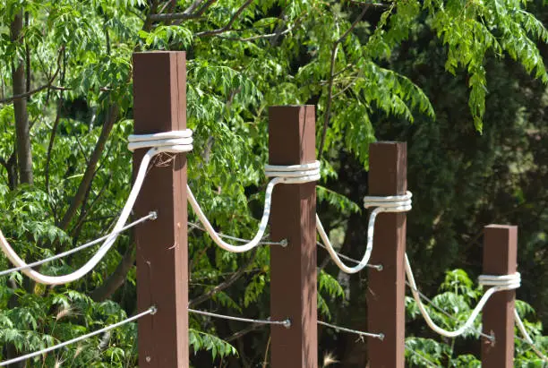 wooden poles with white rope as a fence in public park