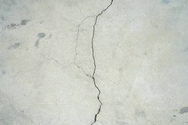 istock Crack raw cement wall or concrete floor background 1414199979