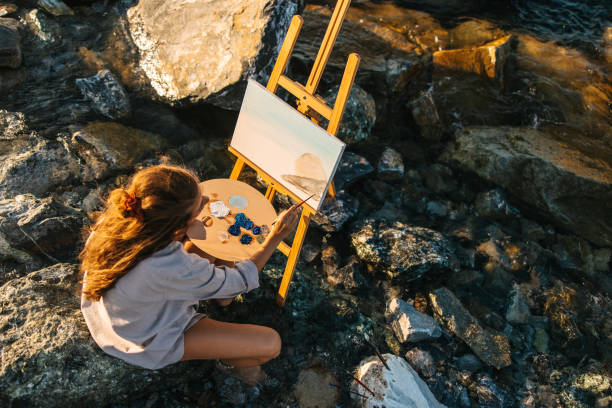 istock Woman painting by the sea 1414200095