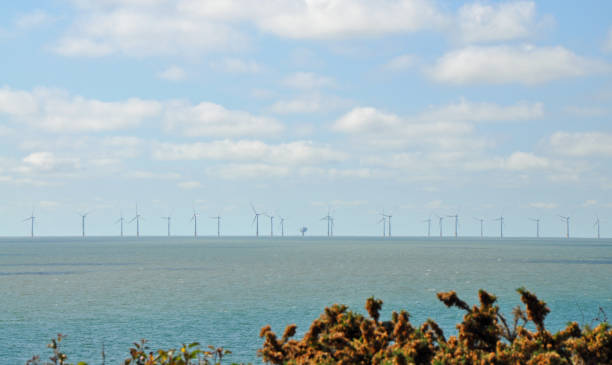 Distant view of Gunfleet Sands wind turbines farm, Essex Distant view of Gunfleet Sands wind turbines farm.  Outdoors on a hot sunny summer day. Off the coast of Clacton on Sea, Essex, August 9, 2022 clacton on sea stock pictures, royalty-free photos & images