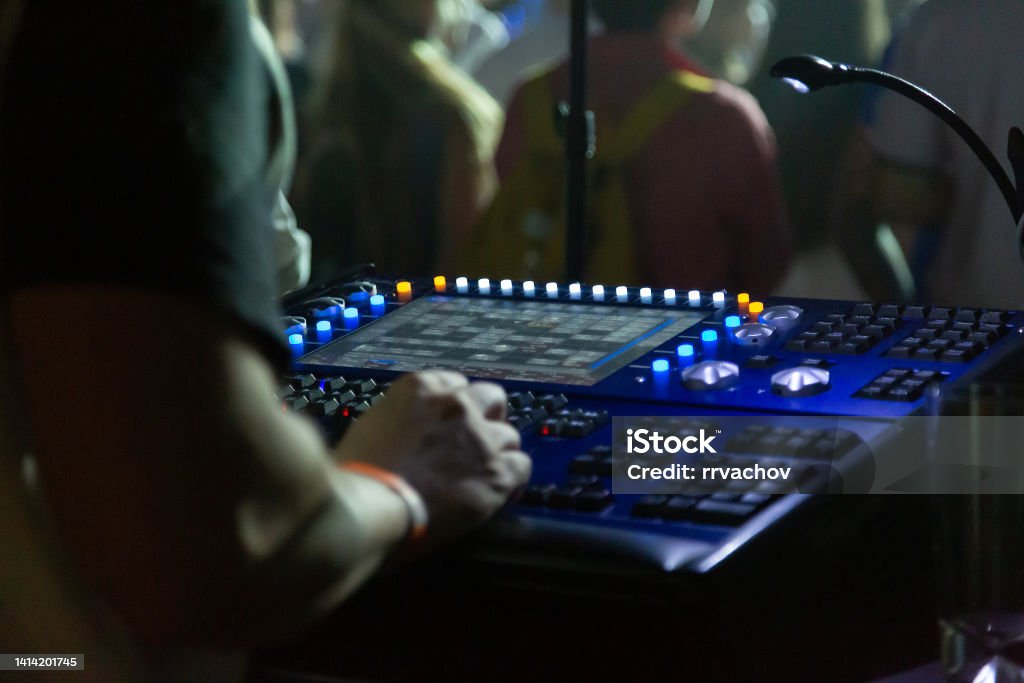 Soundman working on the mixing console in concert hall. Audience Stock Photo