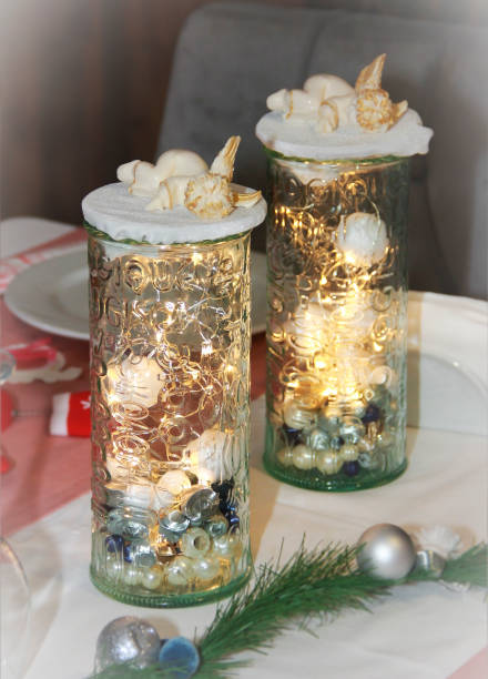 istock New Year's holiday table decoration, glass container with illumination and a sleeping angel 1414202952