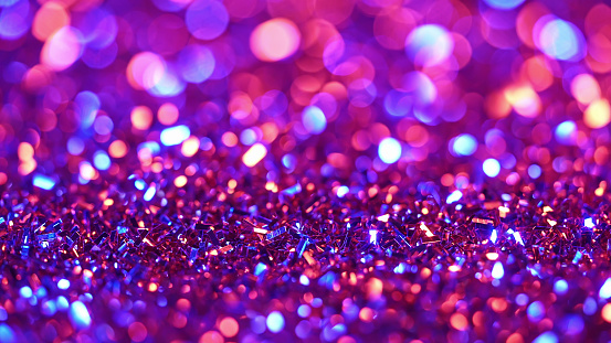 Festive glitter background. Colorful neon light. Abstract sparkles shining, beautiful texture, bokeh. High quality photo