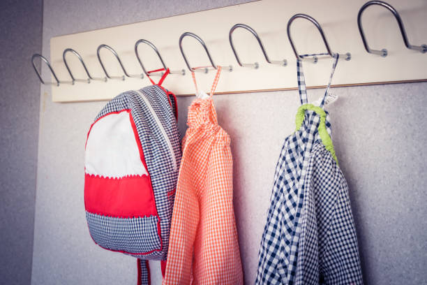 backpack and school bibs hanging on the hanger stock photo
