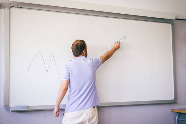 teacher giving class at school on a white board stock photo