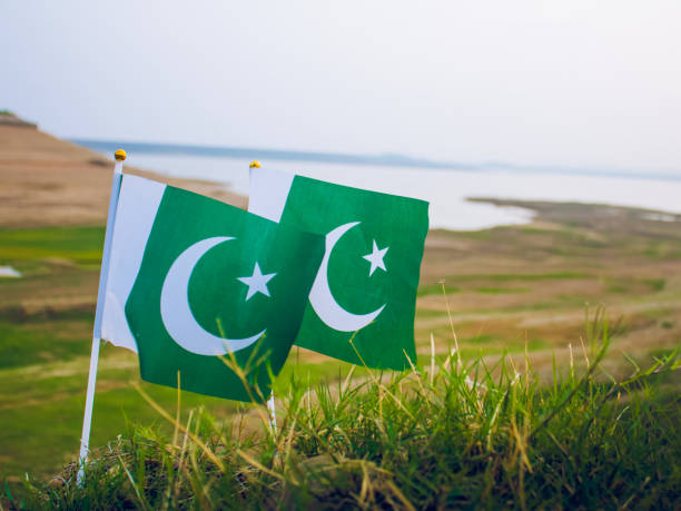 istock Pakistani Flag in grass or fields, river side, independence day 1414208435