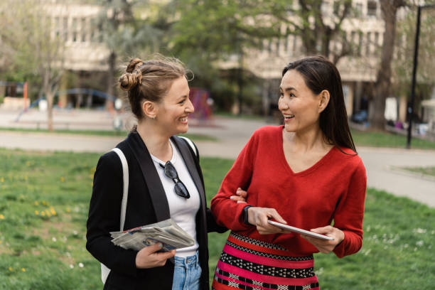 istock Portrait of the two happy women using tablet on the move 1414211596