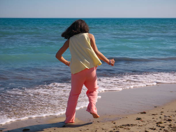 istock Girl seen from behind on the beach 1414214874