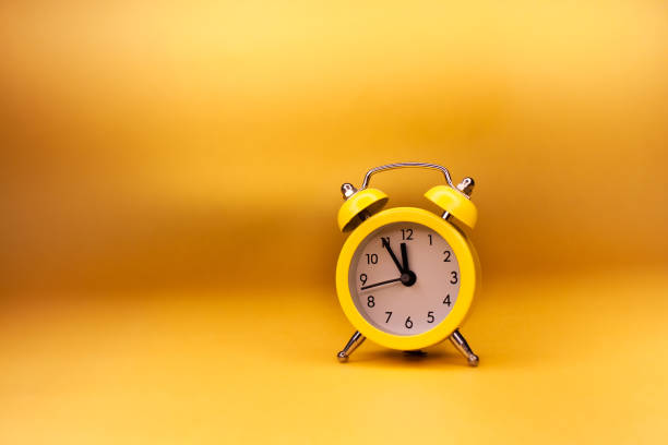 istock Small office yellow alarm clock on yellow background 1414215817