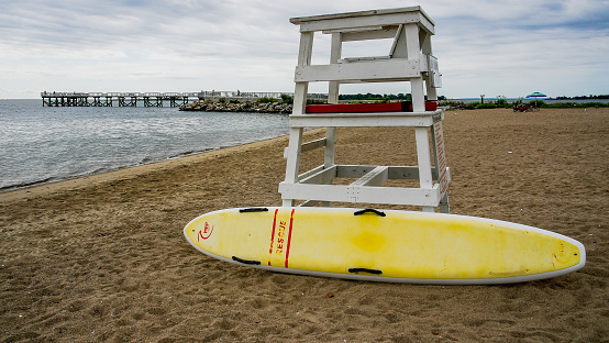 Norwalk, CT USA - August 10, 2022: Lifeguard chair and  fishing pier on  Calf Pasture beach in summer day panorama with copy space