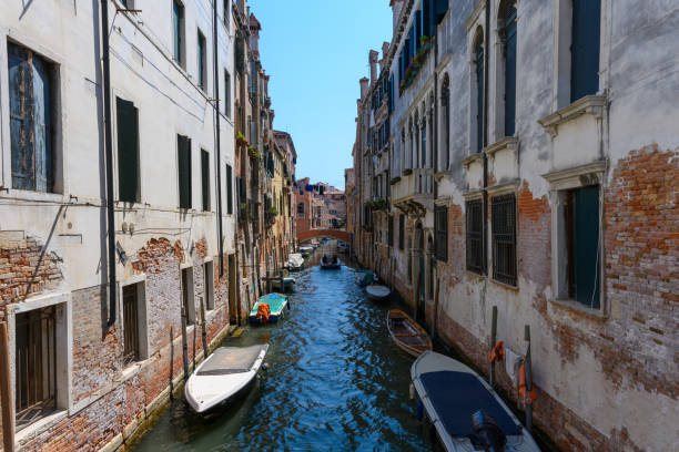 Venice canals, Venice, Veneto, Italy. July 25, 2022. Editorial stock picture of boats sailing, or boats docked in the canals of the beautiful city of Venice, Italy.