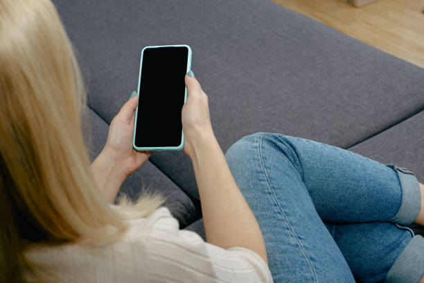 istock A woman at home sitting on the couch communicates with relatives via video call using a smartphone. Young woman making video call with her family 1414219292