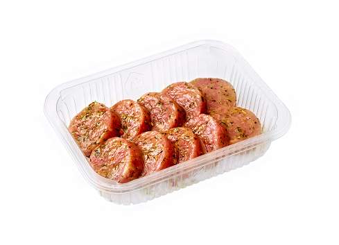 A tray containing a selection of fresh raw meats - white background