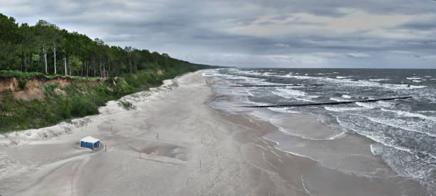 inquieto mar baltico dopo una tempesta. costa baltica polacca vicino alle città di dziwnow e trzesacz. spiaggia vuota, onde tempestose. - out of season foto e immagini stock