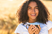 gemischtrassige-afroamerikanische-teenager-frau-die-kaffee-im-freien-trinkt.jpg?b=1&s=170x170&k=20&c=GaDx3416u6BQMurNIRDDRbP9l4W8VakoCLJLBzojsyQ=